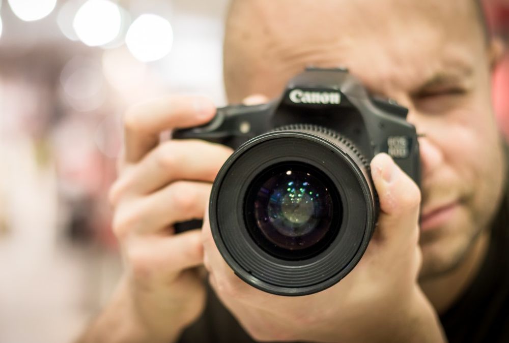 Photographer using the a Nikon D series DSLR Camera.